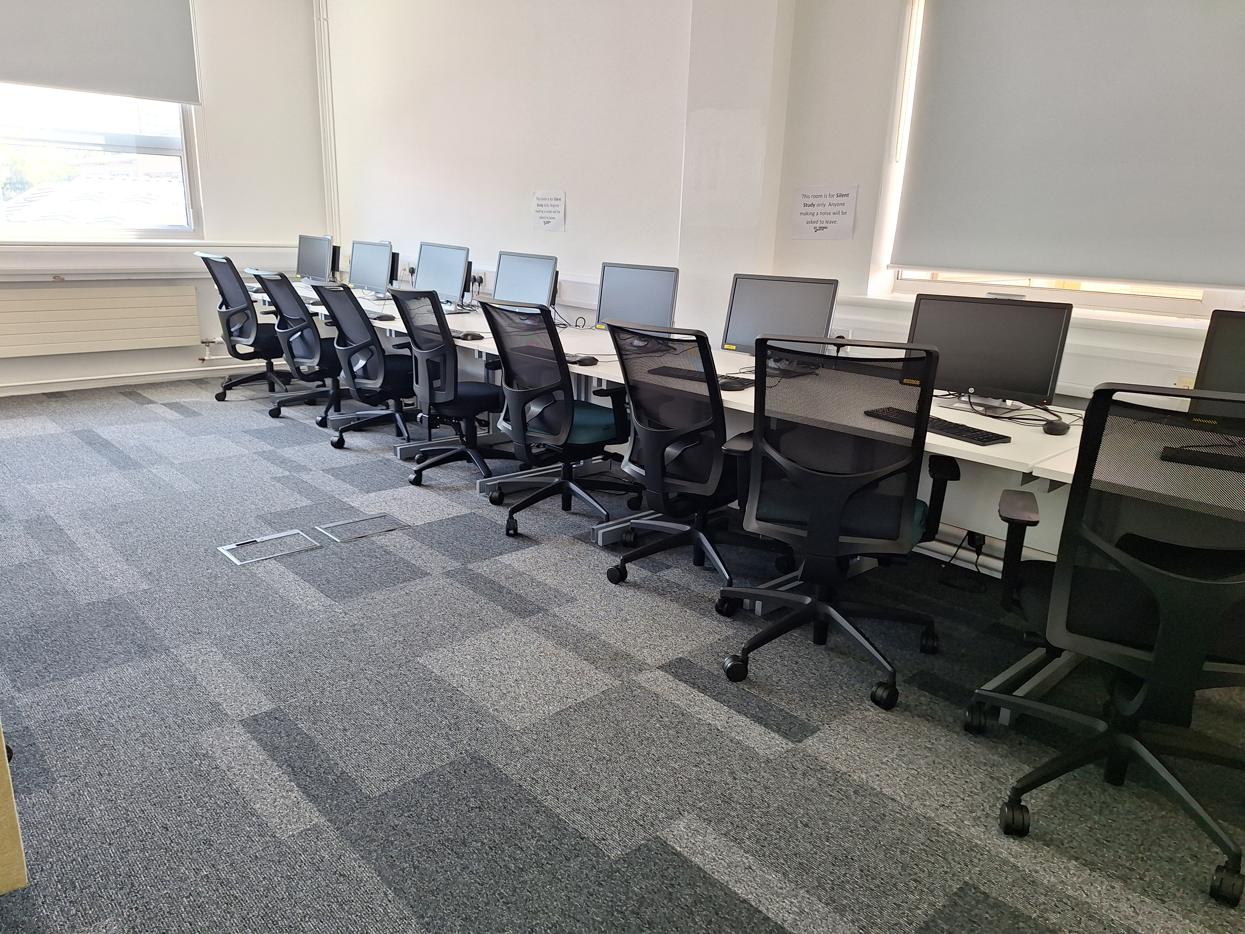 Image showing a set of 8 desks with seats and a computer at each desk