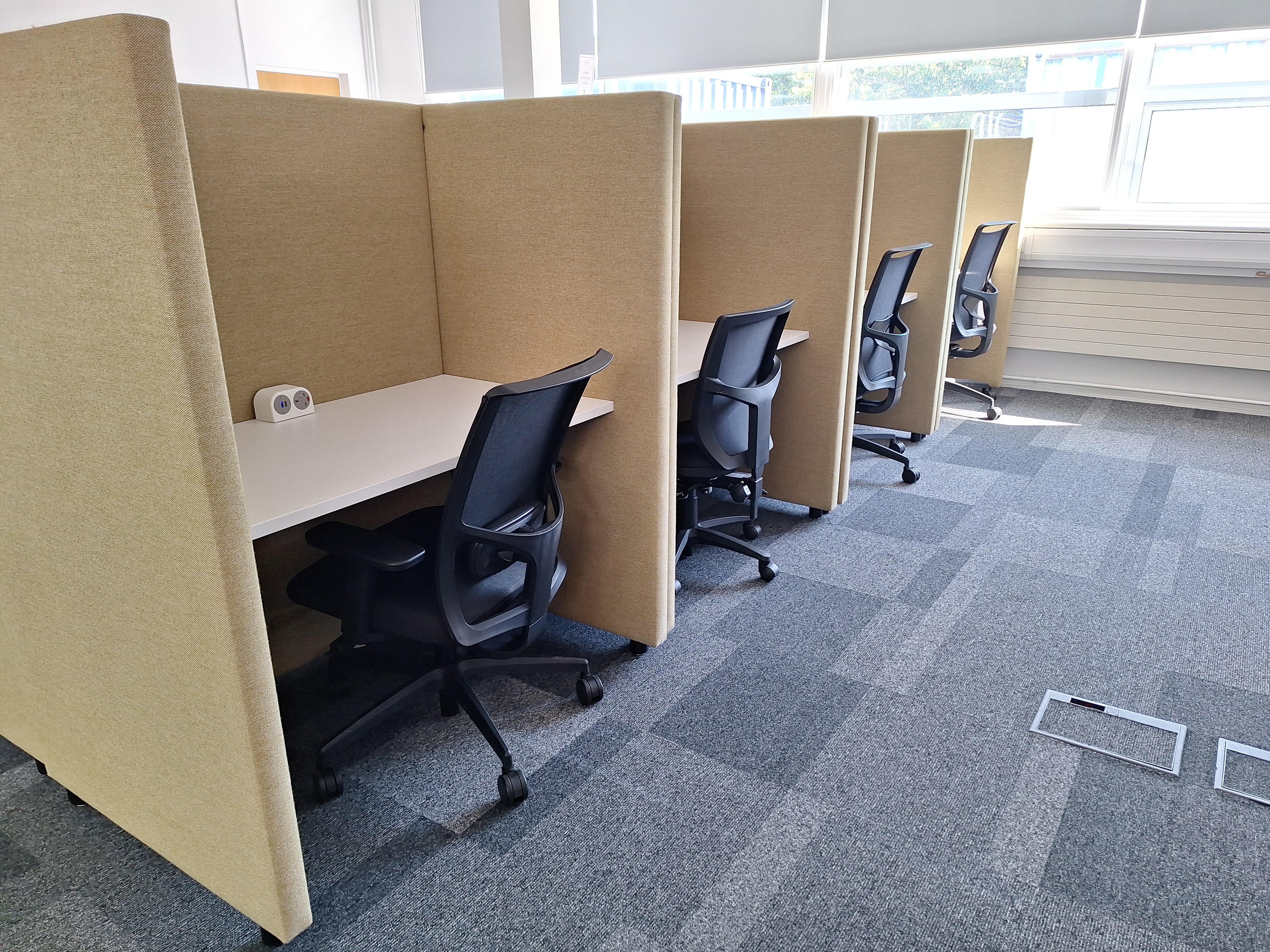 Image showing four high backed study booths with a desk and chair at each one.