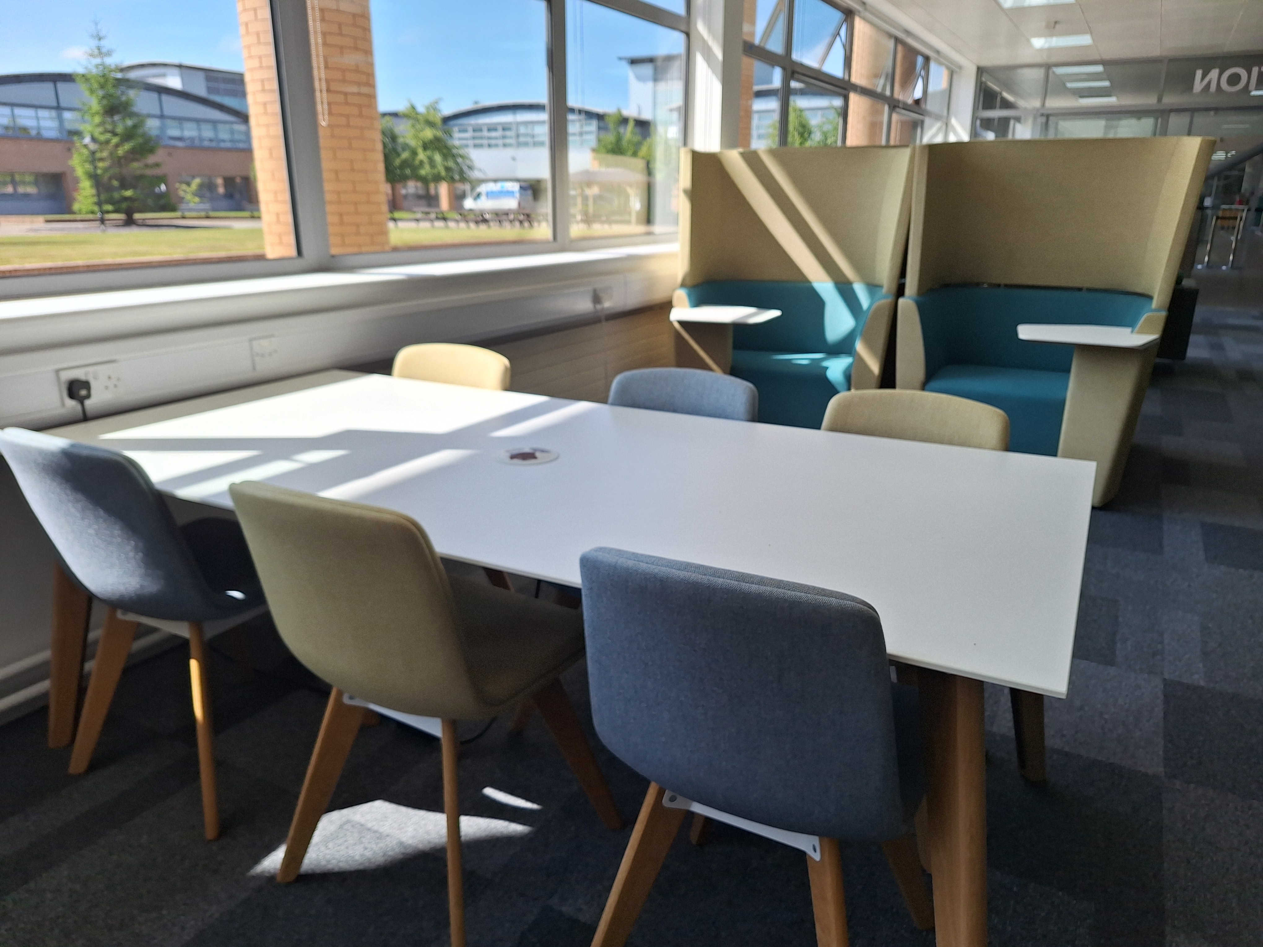 Image showing a desk with 6 seats around it with the college square in the background